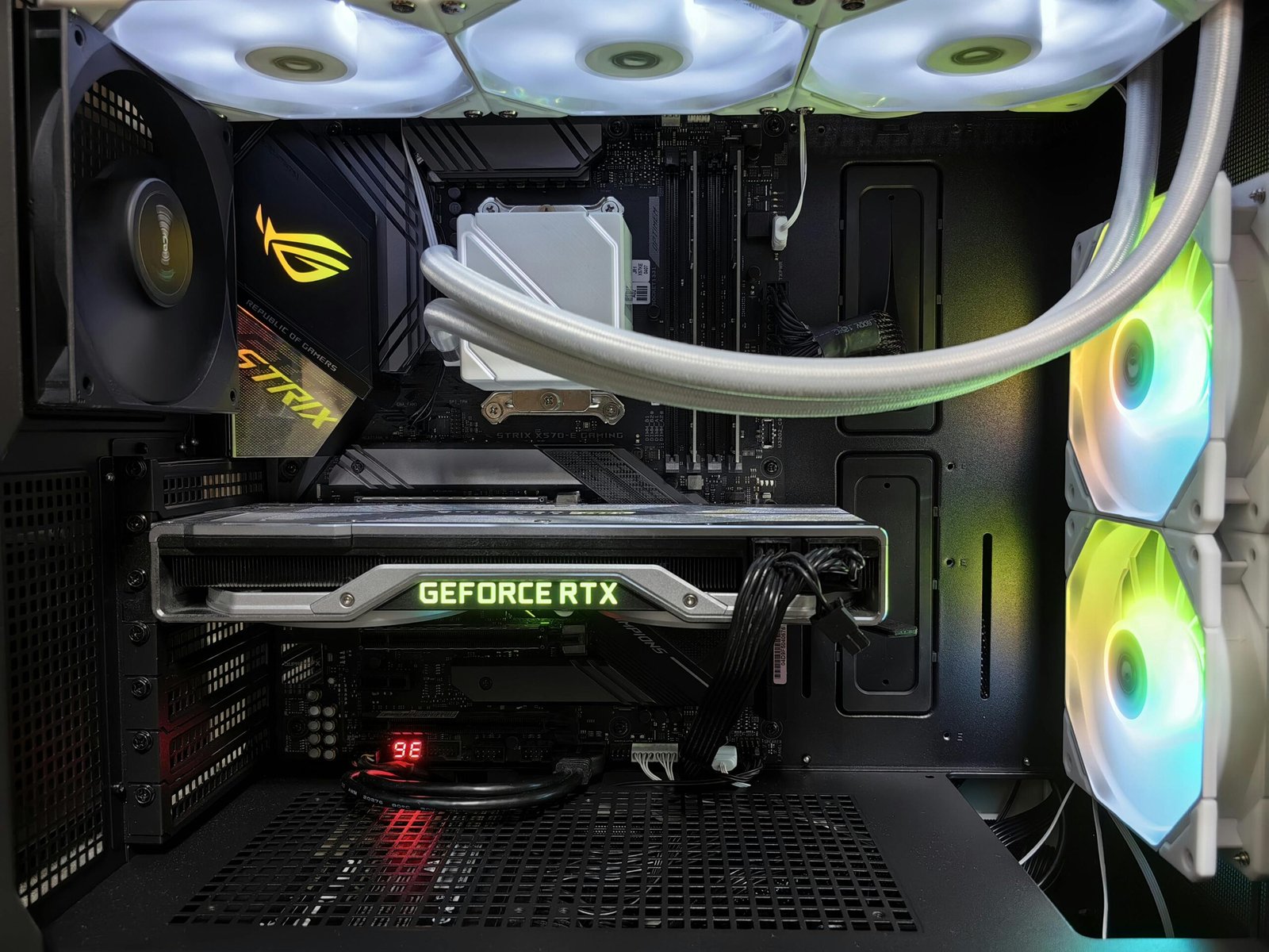 Detailed view of a gaming PC build featuring a GeForce RTX graphics card and RGB lighting in a sleek black case.